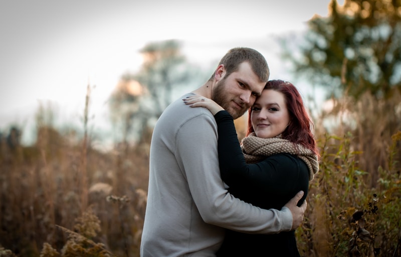 Happy couple embracing outdoors during golden hour event portrait session in Madison, Wisconsin