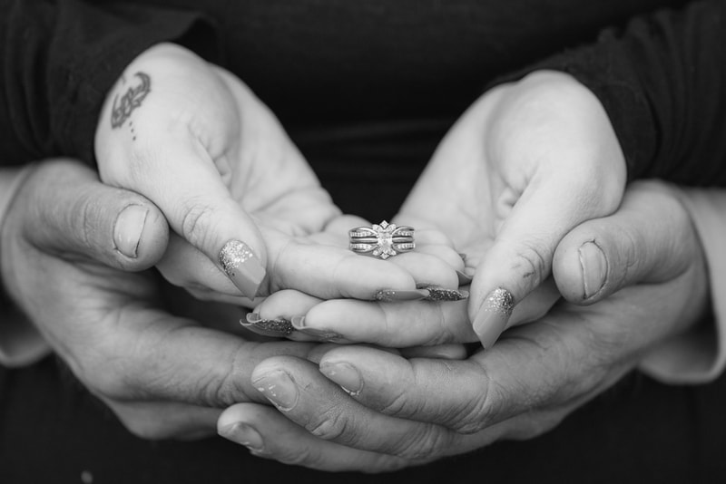 Tender hands cradling diamond engagement ring during intimate wedding event photography session in Madison, Wisconsin