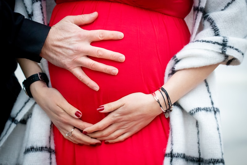 Expecting couple tenderly cradles baby bump during intimate maternity session in Madison, Wisconsin