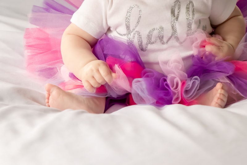 Baby girl in pink and purple tutu celebrates milestone moment in Madison, WI portrait session