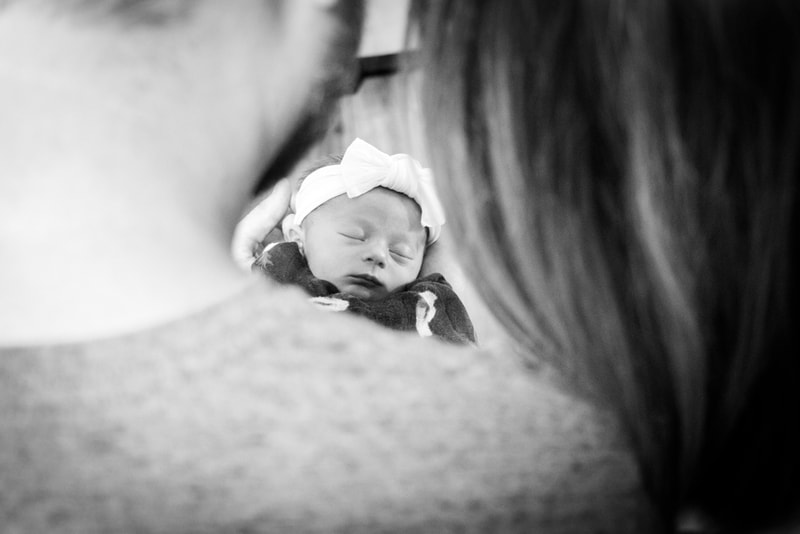 Peaceful sleeping newborn in knit hat and sweater, intimate black and white portrait by Madison, WI photographer